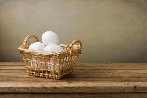 Eggs in basket on wooden table