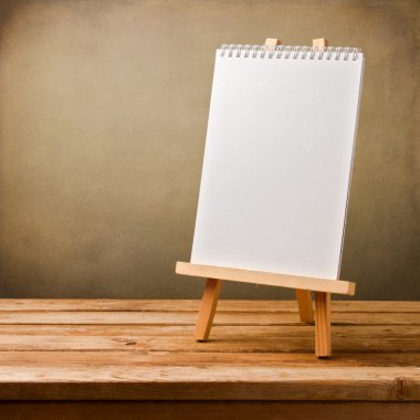 şövale üzerinde ahşap masa üzerinde boş not defteri