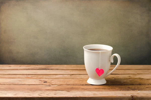 木製のテーブルの上のハートの形とお茶のカップ — ストック写真