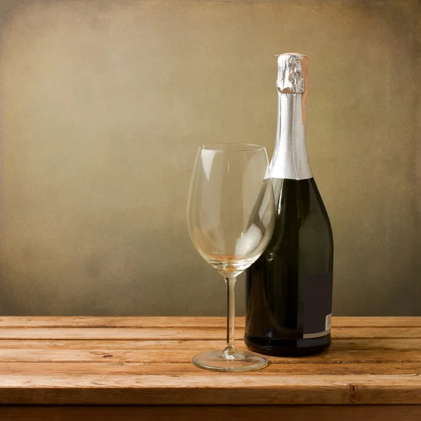 Μπουκάλι κρασί με κενό γυαλί στο ξύλινο τραπέζι — Φωτογραφία Αρχείου