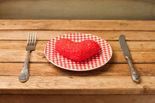 Plate with heart, knife and fork on wooden table — Stock Photo, Image