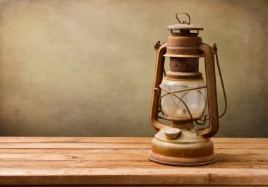 Vintage kerosene lamp on wooden table clipart