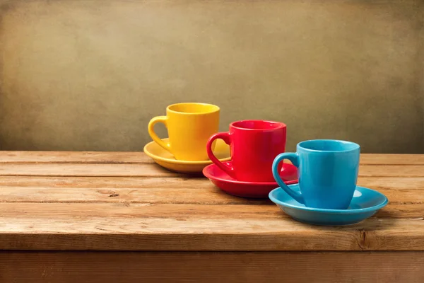 Bunte leere Kaffeetassen auf Holztisch — Stockfoto