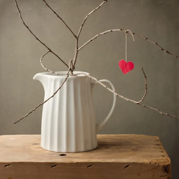 Paper heart hanging on tree branch in white jug — Stock Photo, Image