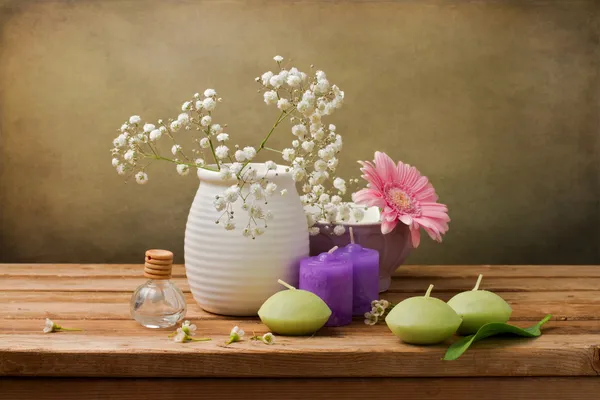 Stilleven met bloemen en kaarsen op houten tafel — Stockfoto