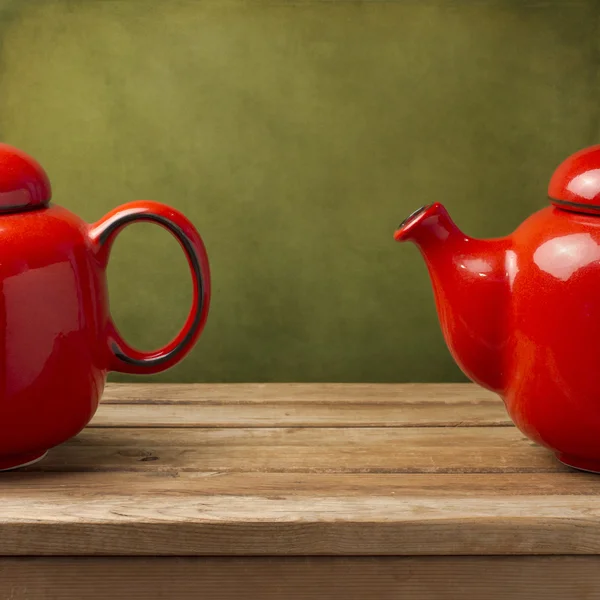 Фон с красным чайником над зеленой стеной — стоковое фото