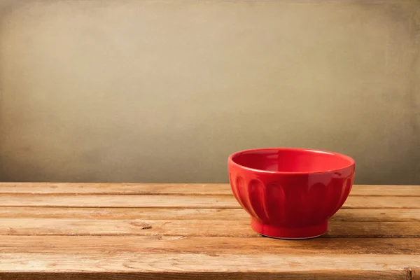 Empty red bowl on wooden vintage table — Stock Photo, Image