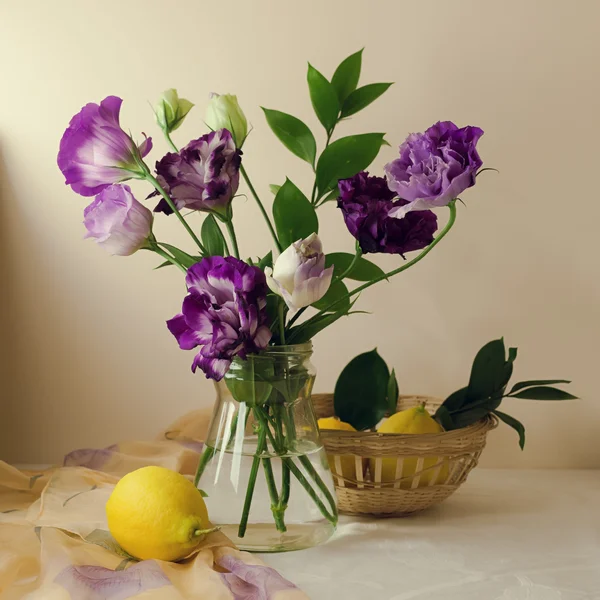 Beautiful purple flowers with lemons — Stock Photo, Image