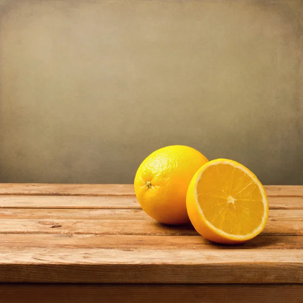 Fruta laranja na mesa vintage de madeira sobre fundo grunge — Fotografia de Stock