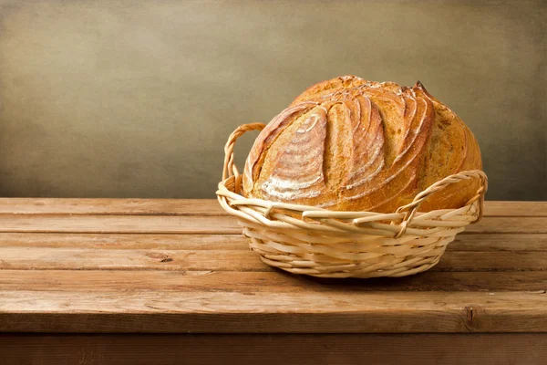 Fresh bread in basket on wooden vintage table — Stock Photo, Image