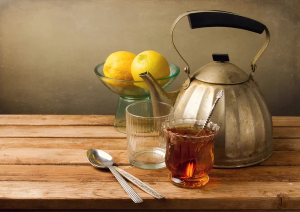 Vintage still life with teapot and lemons on wooden table — Stock Photo, Image
