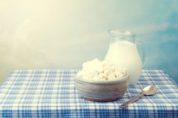 Queijo de casa de campo e leite na toalha de mesa sobre belo fundo — Fotografia de Stock