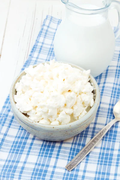 Cottage cheese and milk on checked blue tablecloth — Stock Photo, Image