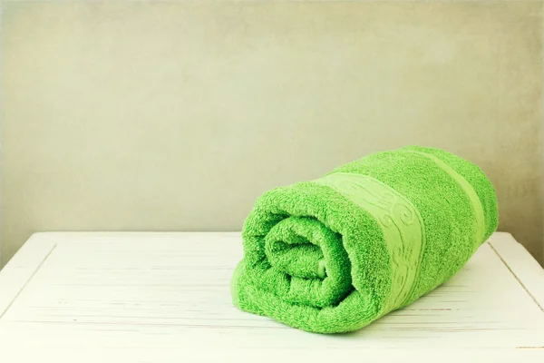 Fresh clean towel on white wooden table