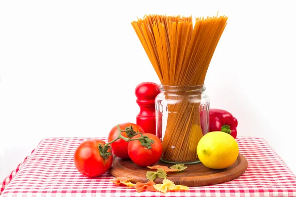 Espaguete e legumes em toalha de mesa vermelha — Fotografia de Stock