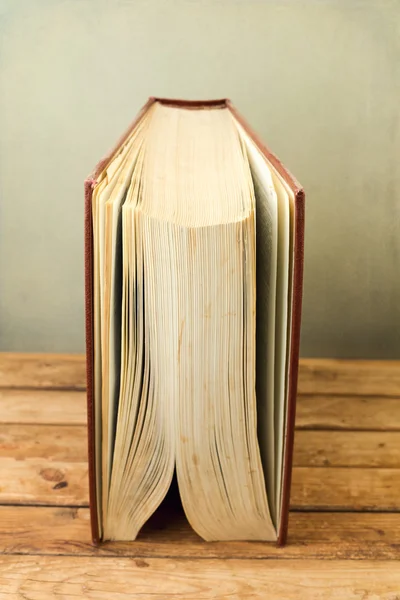 Vintage old book standing on wooden deck table — Stock Photo, Image