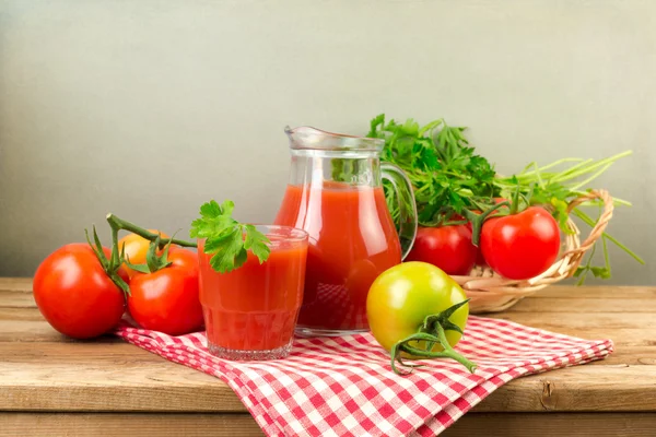 Fresh tomato juice and tomatos on wooden table — Stock Photo, Image