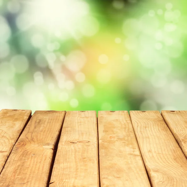 Houten dek tafel over mooie bokeh achtergrond — Stockfoto