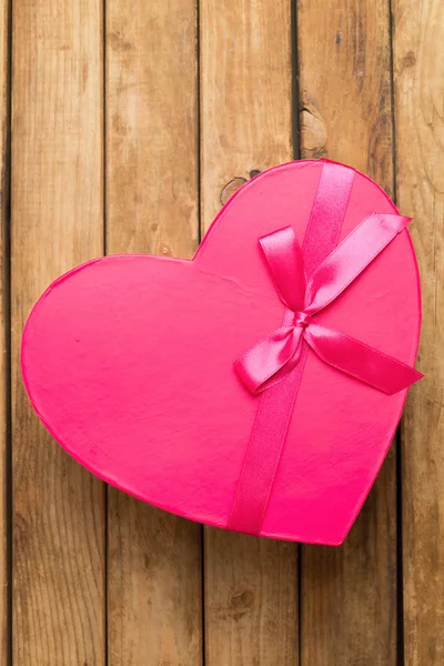 Caja de regalo en forma de corazón sobre fondo de madera — Foto de Stock