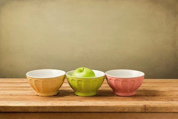 Colorful bowls with green apple — Stock Photo, Image