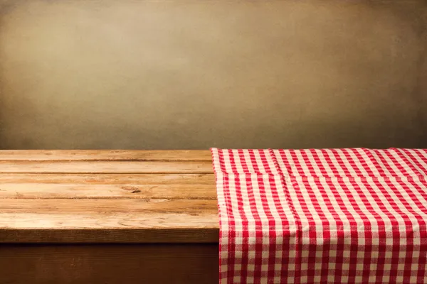 Άδειο ξύλινο τραπέζι καλυμμένο με κόκκινο ελεγμένο τραπεζομάντιλο — Φωτογραφία Αρχείου