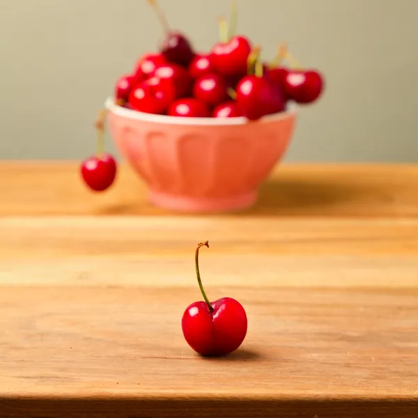 Single cherry över full skål av körsbär — Stockfoto