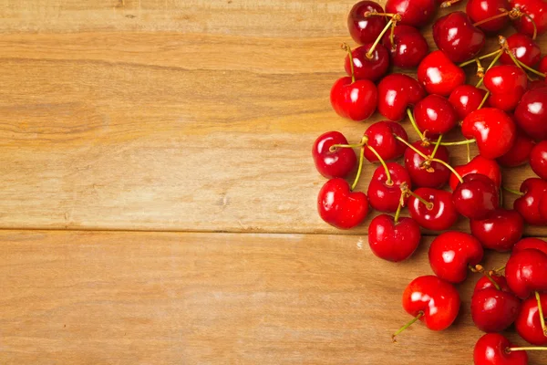 Fond en bois avec des cerises rouges fraîches — Photo