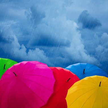 Colorful umbrellas over cloudy sky