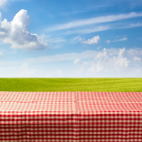 Empty table covered with checked tablecloth — Stock Photo, Image