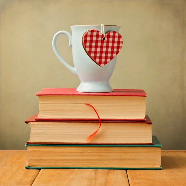 Caneca de café com forma de coração em livros vintage — Fotografia de Stock