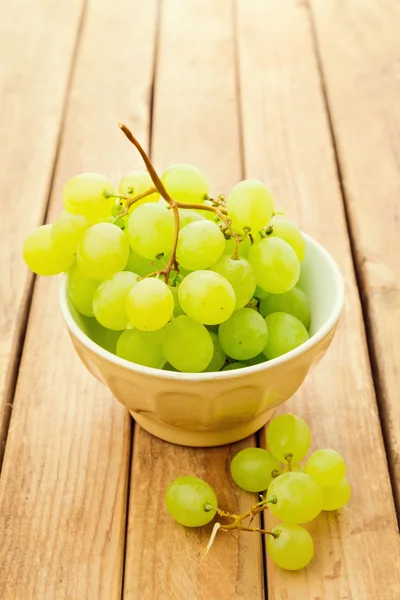 Grapes in bowl over wooden background — Stock Photo, Image