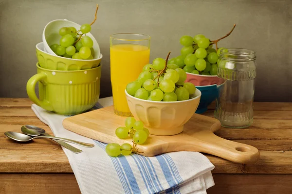 Still life with grapes on wooden table over grunge background — Stock Photo, Image