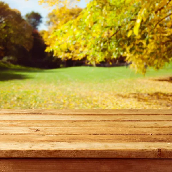 Κενό ξύλινο πίνακα πέρα από το φθινόπωρο πάρκο υπόβαθρο. έτοιμοι για προϊόν μοντάζ — Φωτογραφία Αρχείου