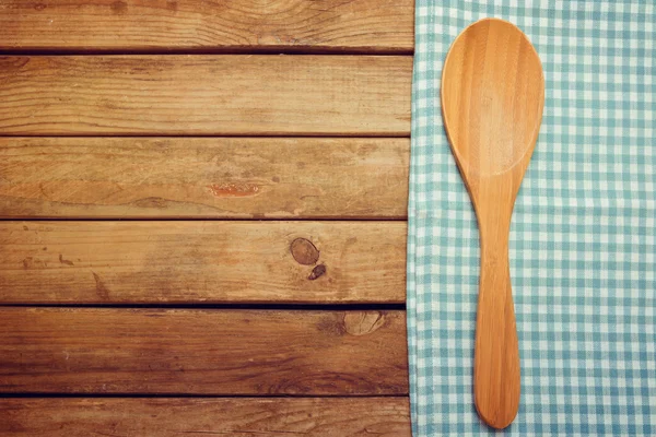 Kochlöffel und Tischdecke über Holzgrund — Stockfoto