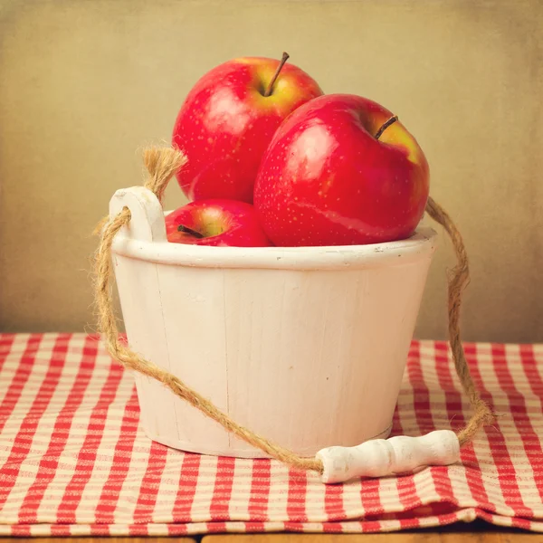 Färska röda äpplen i trä hink — Stockfoto