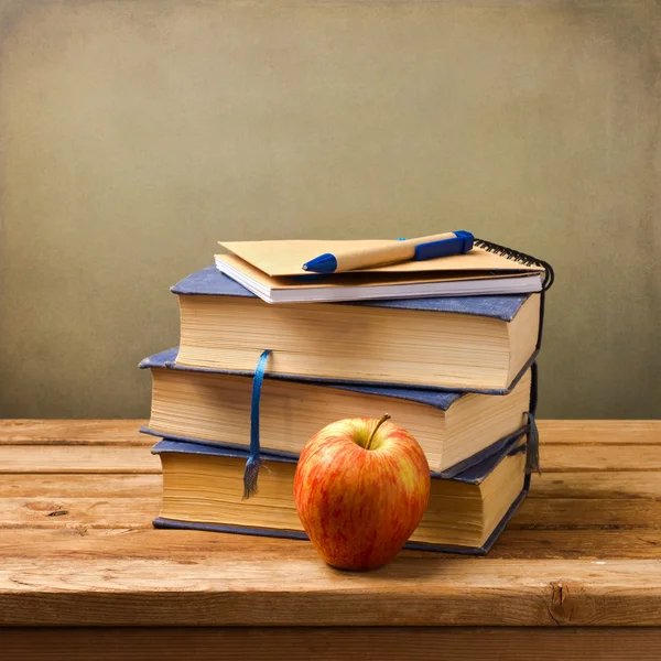 Stack of books with note book and apple. — Stockfoto