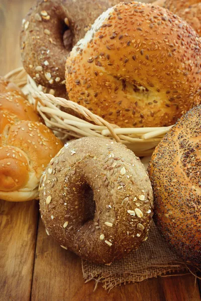 Pão fresco e pães sobre fundo de madeira — Fotografia de Stock