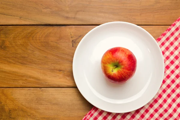 Plate with apple on wooden background — Stock Photo, Image