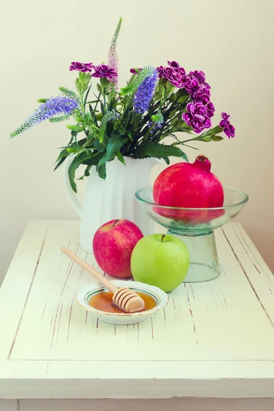 Manzana con miel, granada y flores — Foto de Stock