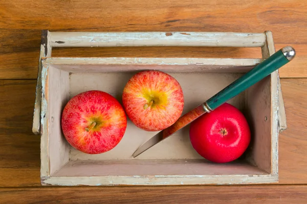 Μήλα σε ξύλινο κουτί πέρα από το ξύλινο υπόβαθρο — Φωτογραφία Αρχείου
