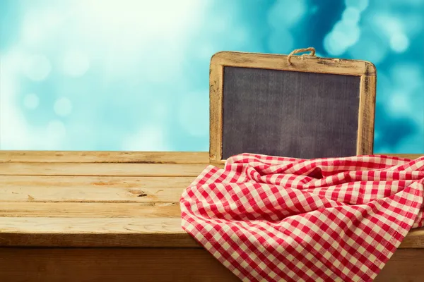 Empty wooden table with chalkboard — Stock Photo, Image