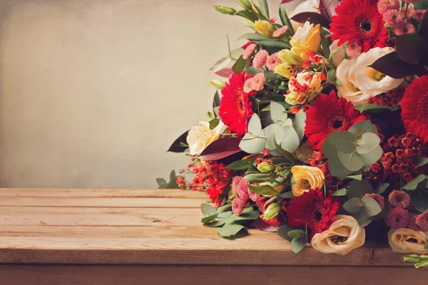 Ramo de flores en mesa de madera — Foto de Stock