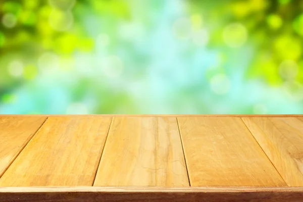 Wooden table over bokeh background — Stock Photo, Image