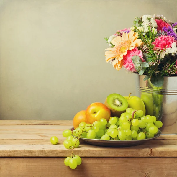 Fruits and flowers in table — Stock Photo, Image