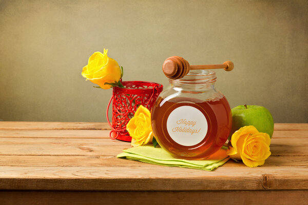 Honey, apple and flowers on wooden table