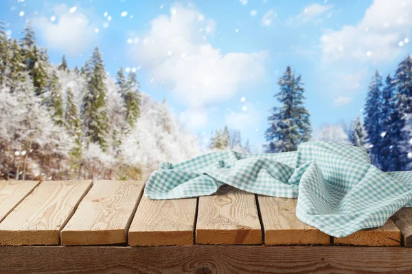 冬の風景の背景にテーブルクロスと空の木製のテーブル クリスマスと新年は デザインや製品の表示のためのモックアップ — ストック写真