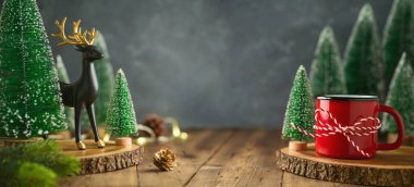 Tahta masada Noel süsleri. Kahve fincanı ve ren geyiği desenli yeni yıl afişi tasarımı