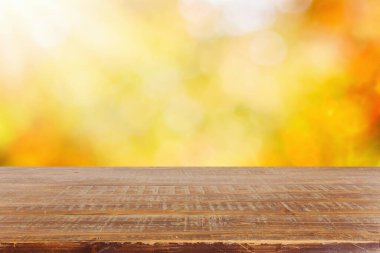 Sonbahar doğa parkının arka planında boş ahşap masa. Tasarım ve ürün gösterimi için piknik modeli