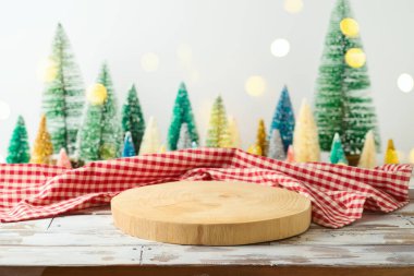 Noel ağacı süsleme arkaplanının üzerinde masa örtüsü olan boş ahşap kütük. Noel ve Yeni Yıl tasarım ve ürün gösterimi için hazırlanıyor.