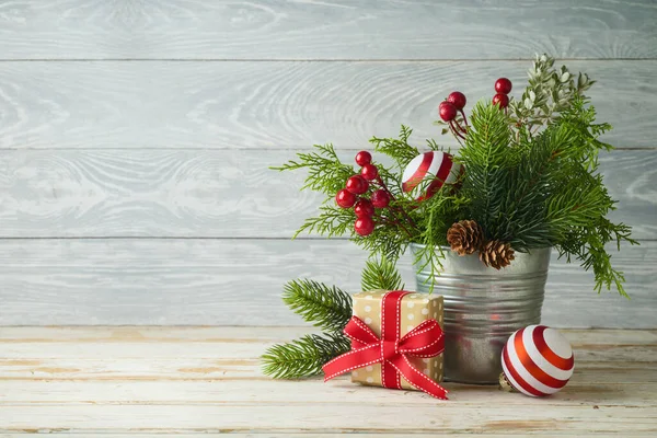 木のテーブルの背景にギフトボックスと装飾が入ったバケツのクリスマス松の木の枝 — ストック写真
